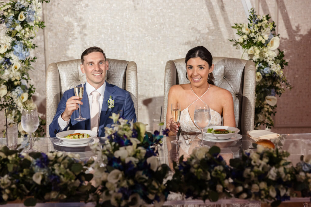 Bride and groom smiling and listening to speeches at The Crescent Beach Club.