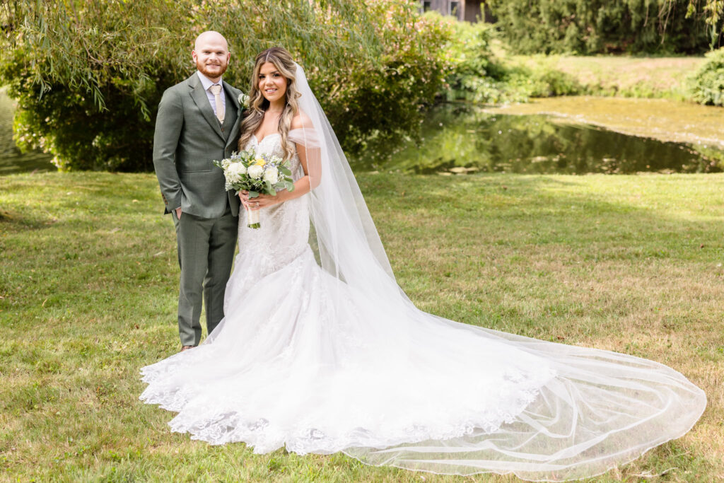 Full length picture of bride and groom on grass at Flowerfield.