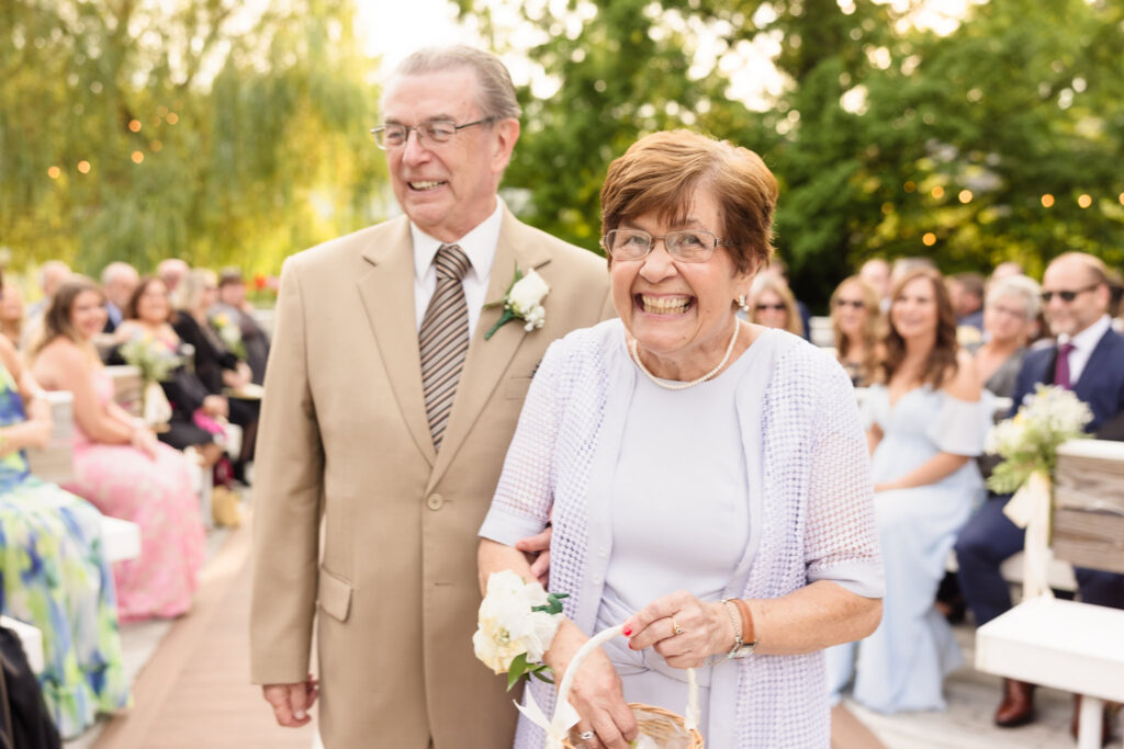 Bride's grandma walking down the aisle with her grandpa. The grandma is the flower girl.