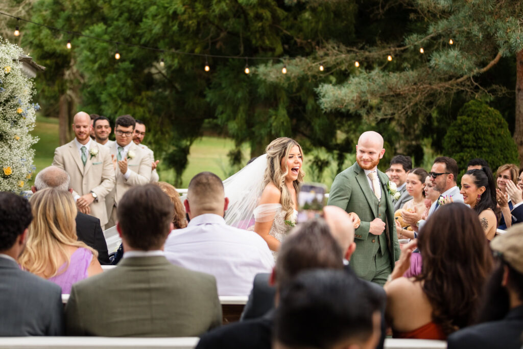 Bride and groom walking down the aisle and celebrating. 