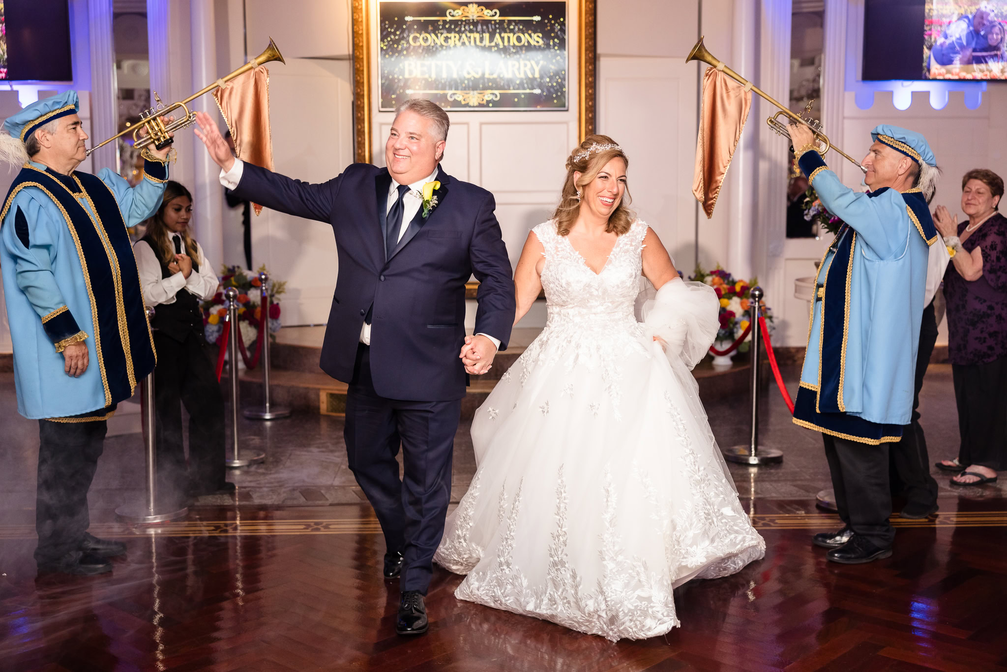 Bride and groom entering reception next to trumpet players at Sand Castle wedding venue