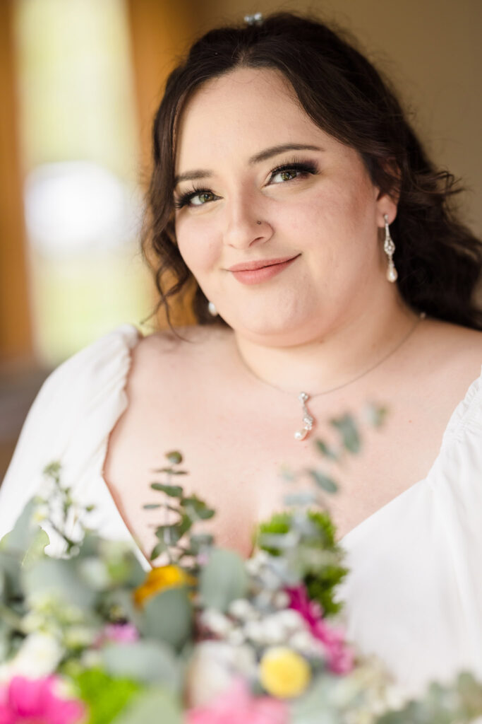 Bride holding flowers and smiling at the camera.