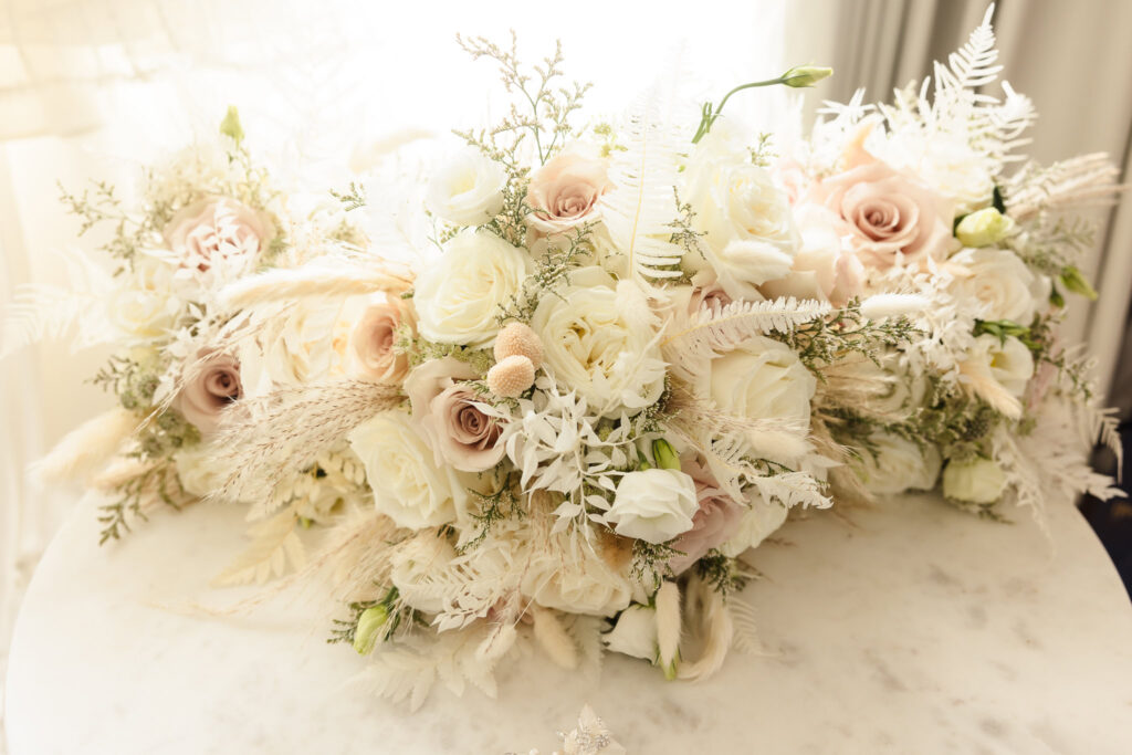 White, pink, and green bouquets on a marble table at the Allegria Hotel.