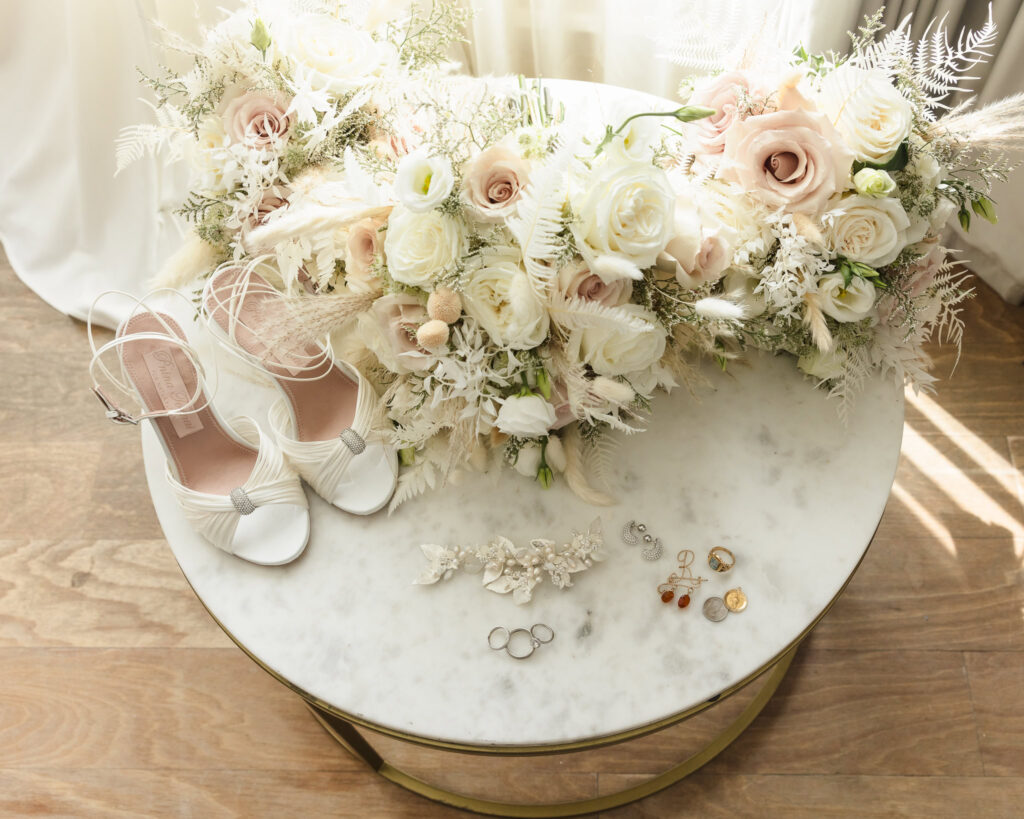 Shoes, bouquet, and jewelry on a marble table at the Allegria Hotel in Long Beach, NY.