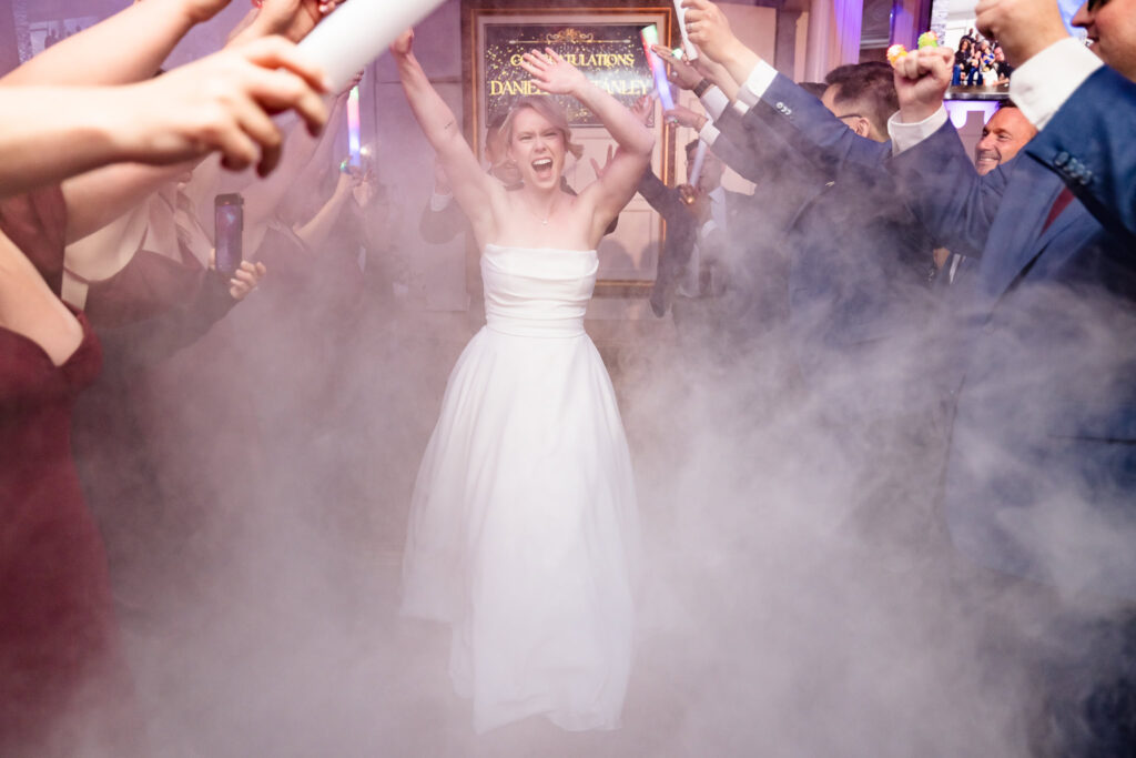 Bride walking into the reception at Sand Castle with fog in the air. 