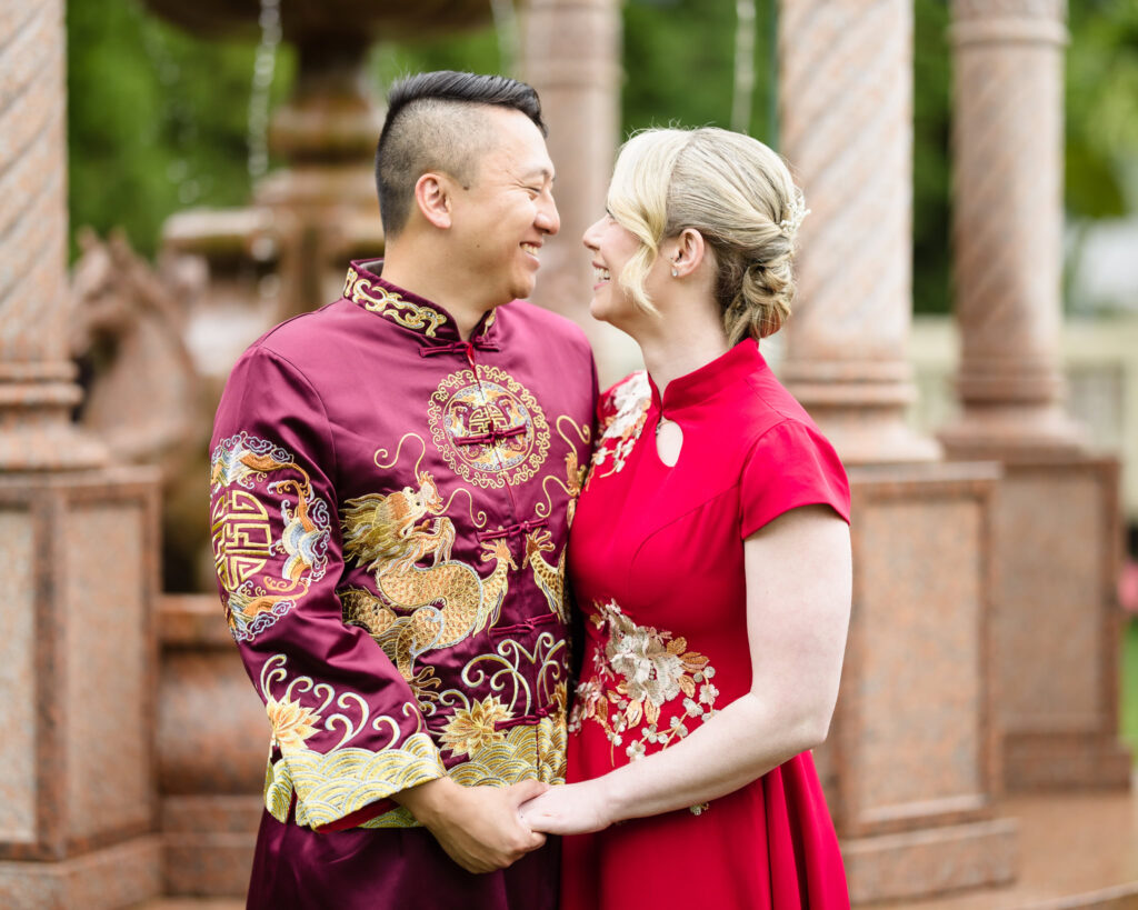 Bride and groom looking at each other and smiling. They are wearing traditional attire at Sand Castle Wedding Venue.