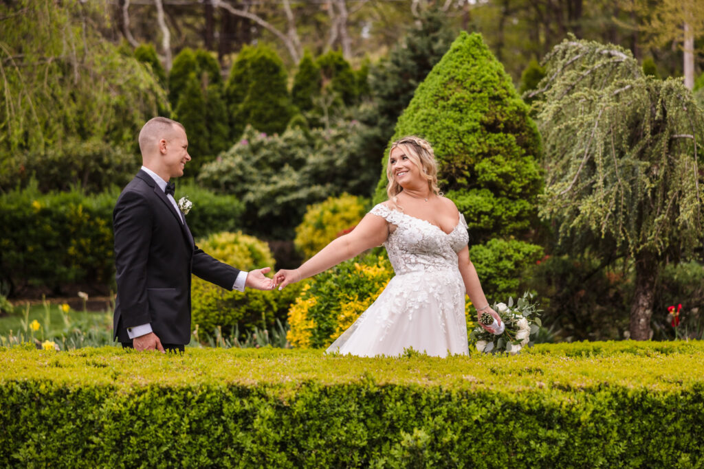 Bride leading the groom through the garden at East Wind Long Island.