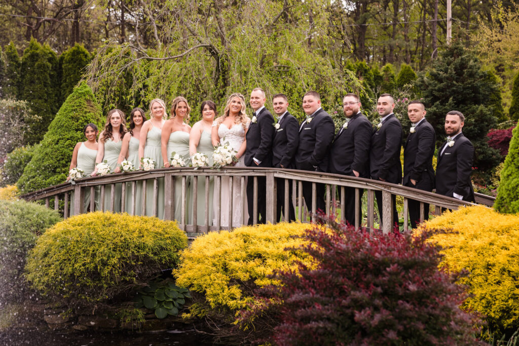 The entire wedding party on the wooden bridge at The Vineyard at East Wind Long Island.