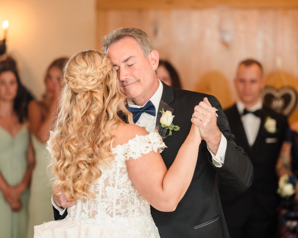 Bride and bride's dad dancing at East Wind Long Island. His eyes are closed and he is smiling. 