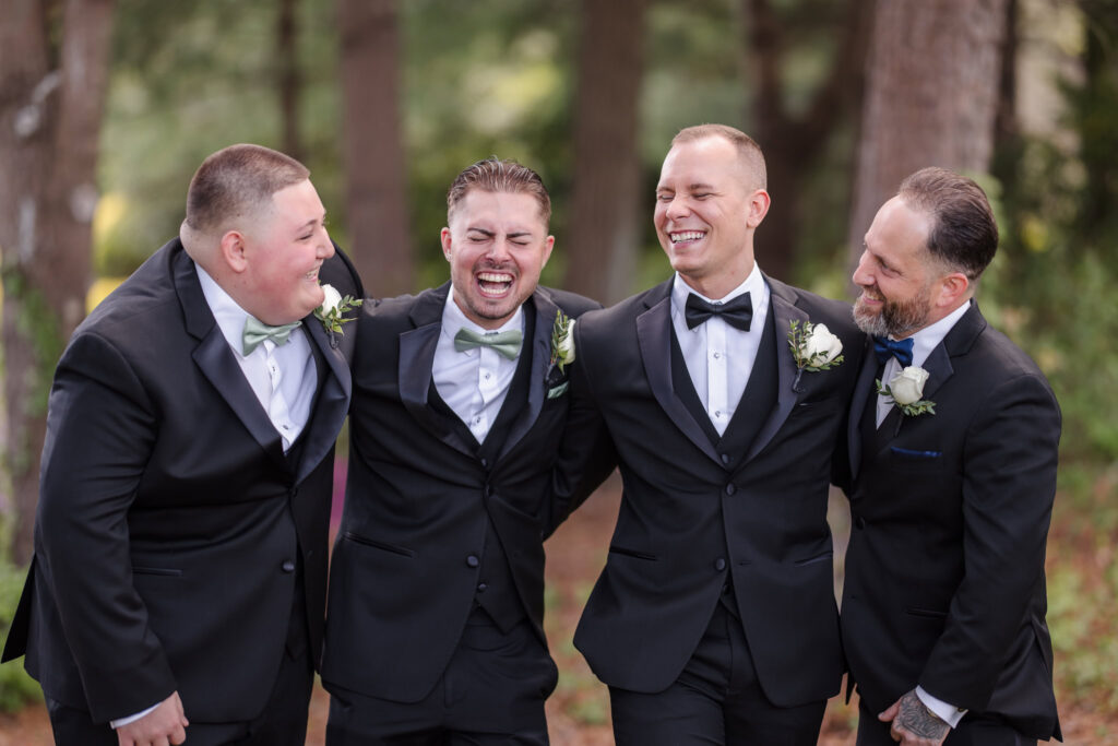 Groom and groomsman laughing and talking to each other at East Wind Long Island.