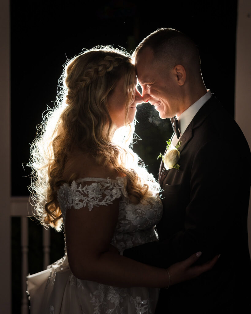 Bride and groom touching foreheads while backlit at East Wind Long Island.