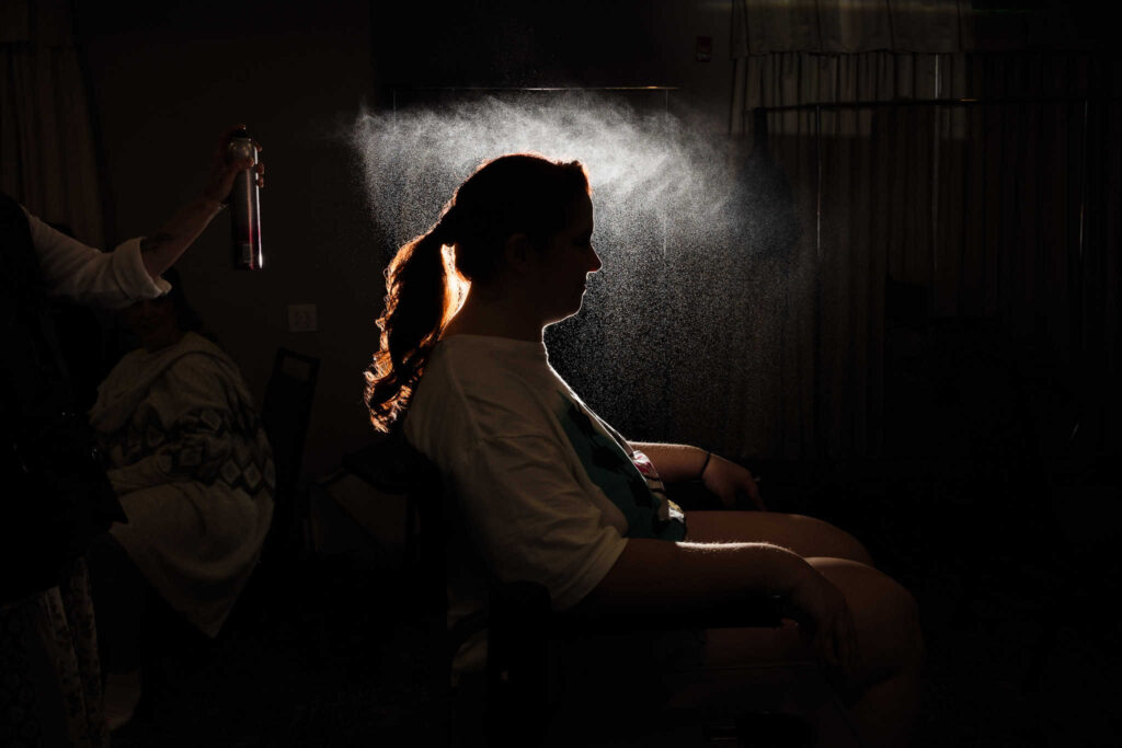 Bride in silhouette with hairspray.