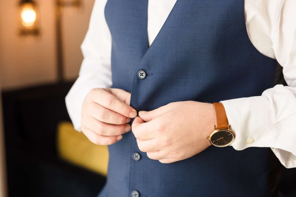 Groom buttoning vest.