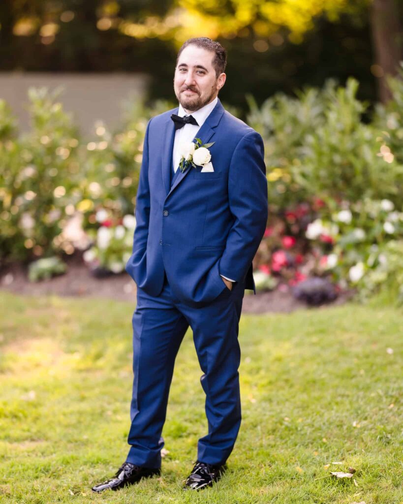 Groom in blue suit looking at camera.