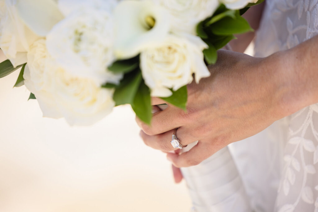 Bride holding bouquet with a close up of wedding ring at Glen Head Country Club.
