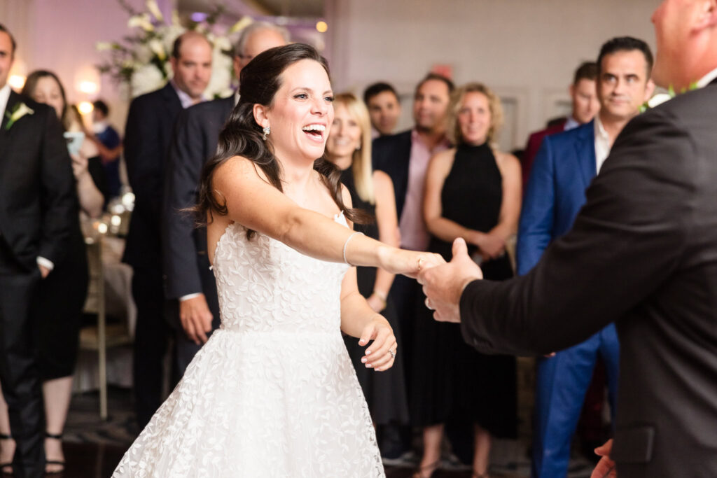 Bride smiling and dancing at Glen Head Country Club. 