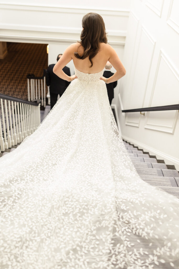 Bride walking down stairs at Glen Head Country Club. 