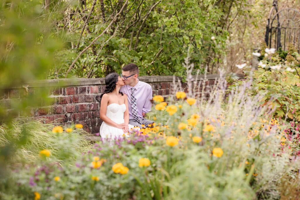 Couple kissing in garden at Planting Fields Arboretum.