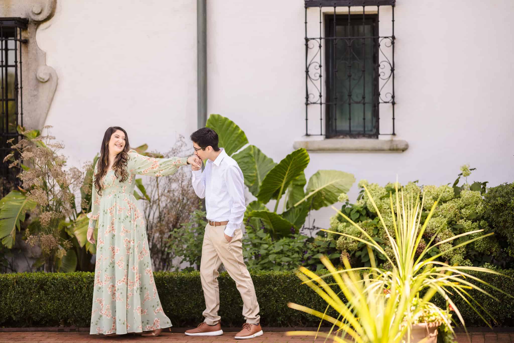 Two people walking at Vanderbilt Museum. The woman is wearing a green dress and the man is wearing a blue shirt.