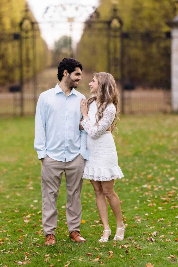 Couple looking at each other by gate at Old Westbury Gardens.