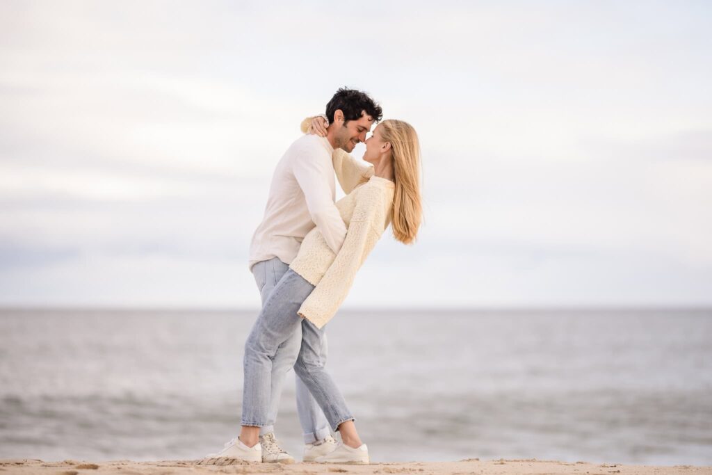 Couple holding each other on beach.