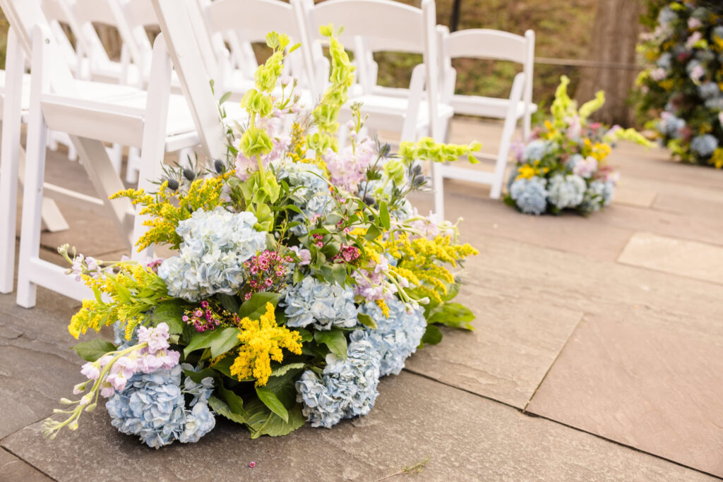 Flowers next to white chair before wedding at New York Botanical Garden.