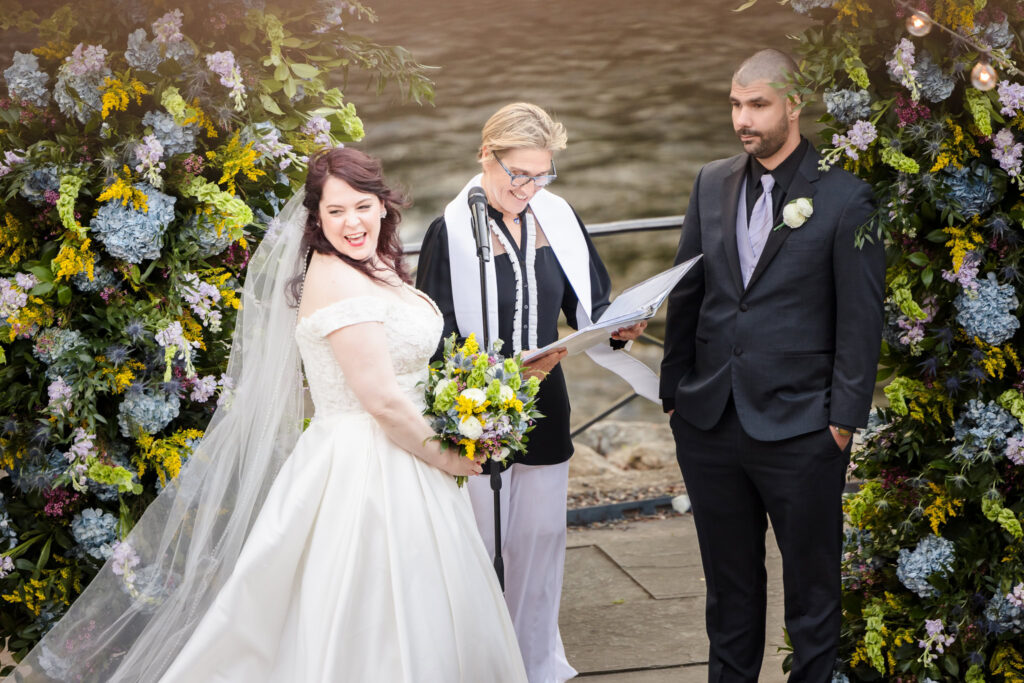 Bride smiling over her shoulder during Stone Mill wedding ceremony at NYBG.