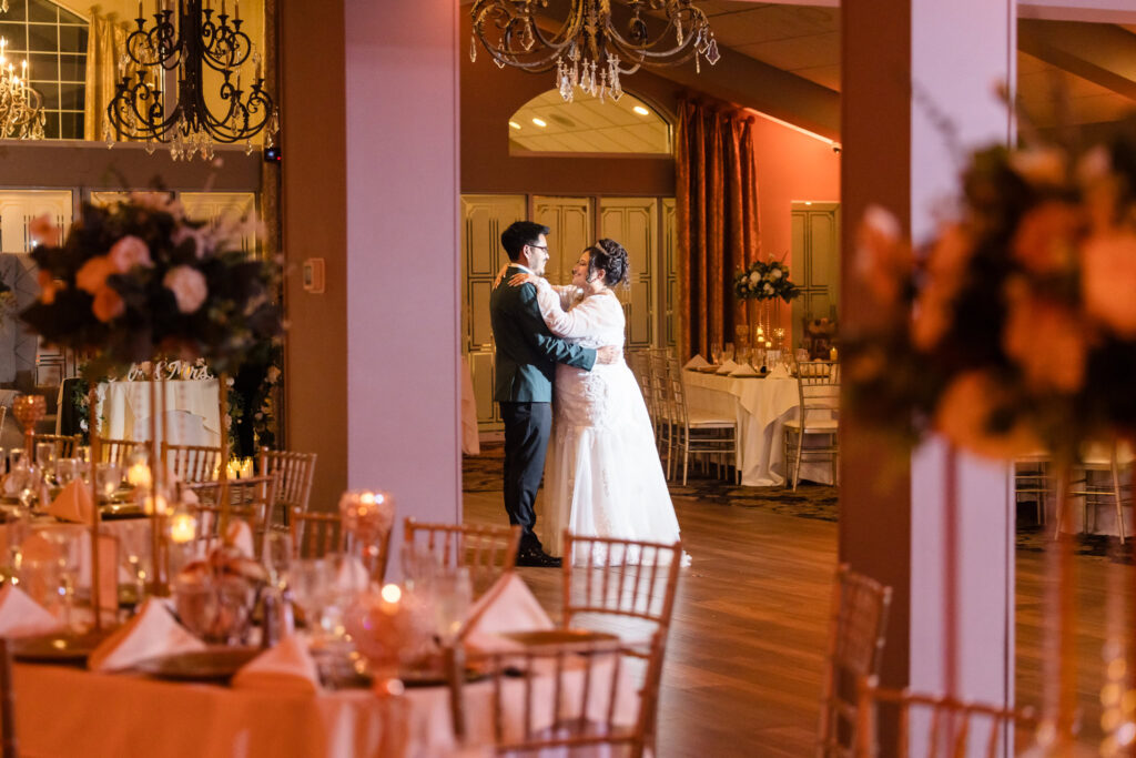 Bride and groom dancing on dance floor at The WaterView. They are alone in the room and smiling at each other. 