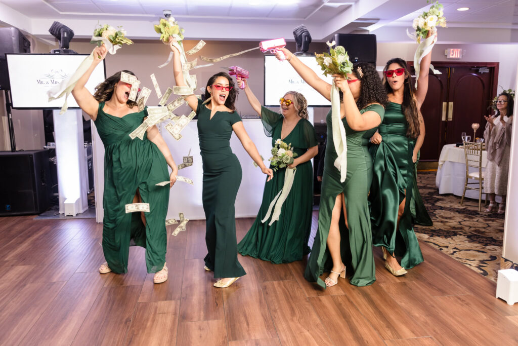 Bridesmaids entering the reception at The WaterView. They are dancing, laughing, and celebrating. 