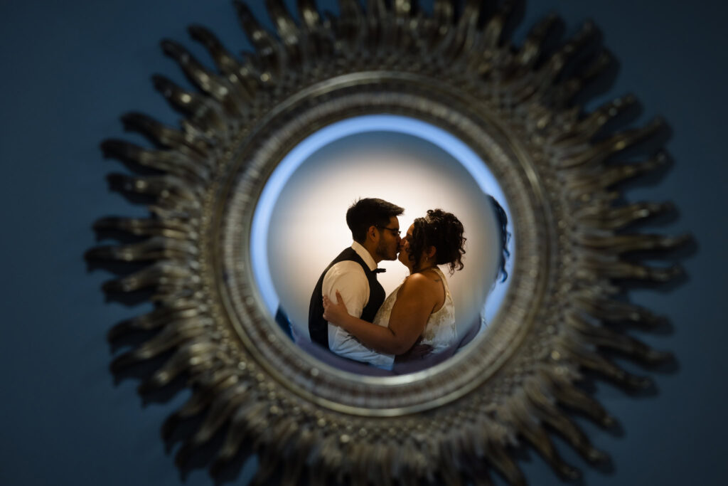 Bride and groom kissing in a mirror at The WaterView at Port Jefferson.