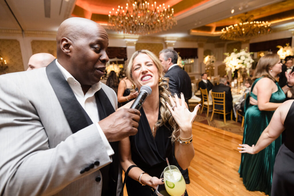 Woman singing on the dance floor with the MC at the Garden City Hotel. 