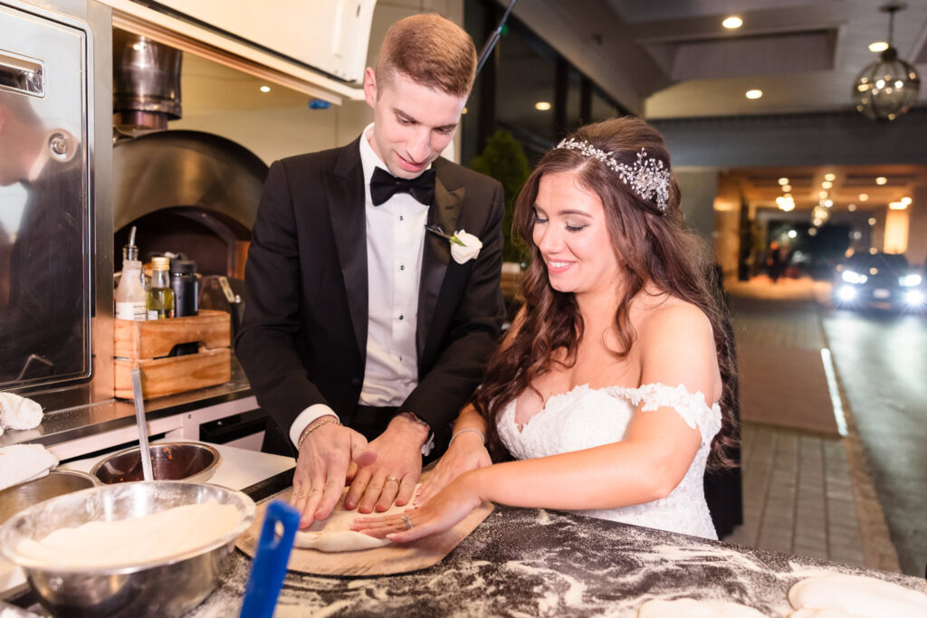 Bride and groom making pizza in front of the Garden City Hotel. 