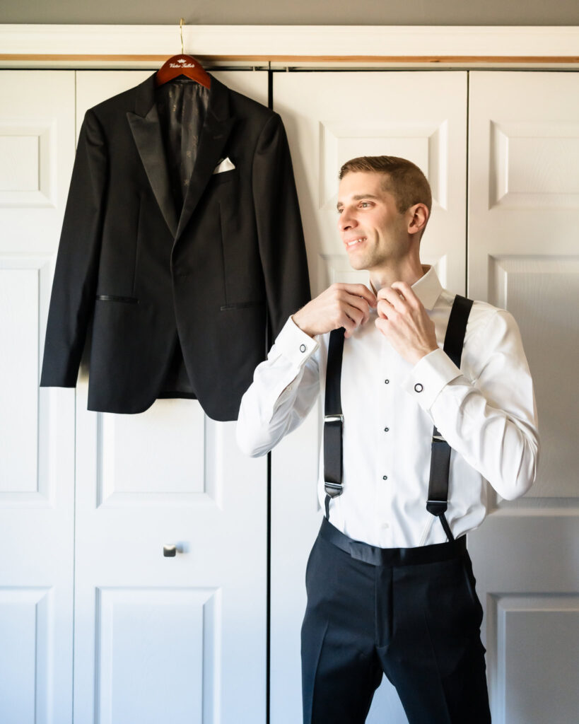 Groom putting on his bowtie. 