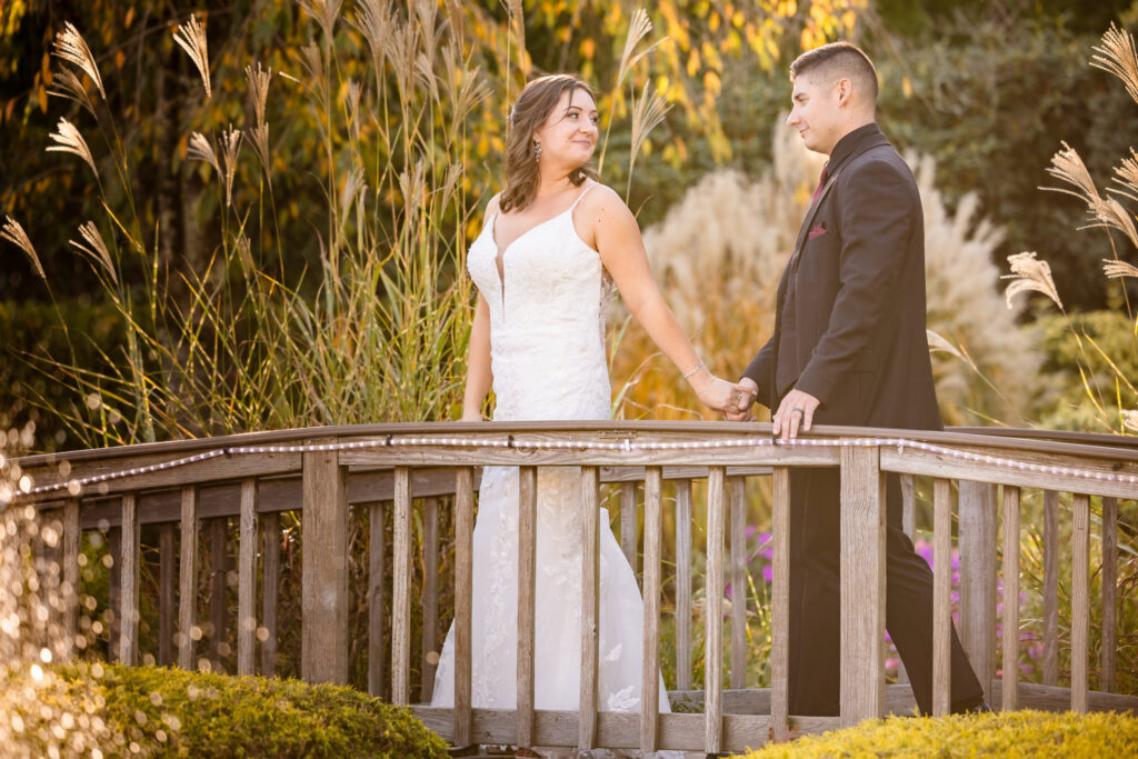 Bride and groom walking over the bridge at the The Vineyard at East Wind Long Island.