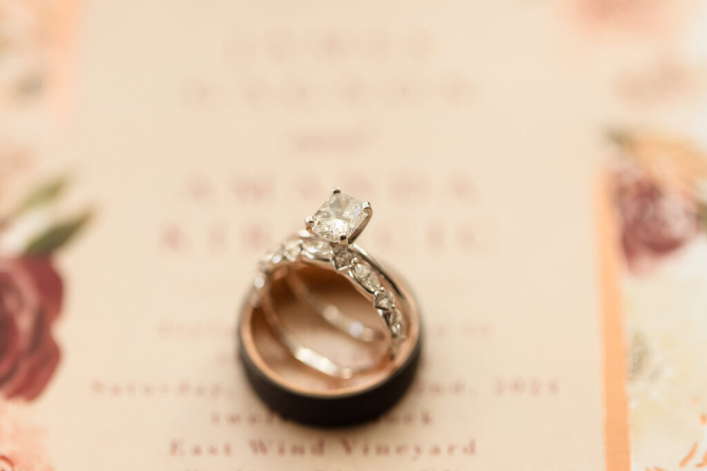 Close up of wedding rings on top of invitation. 