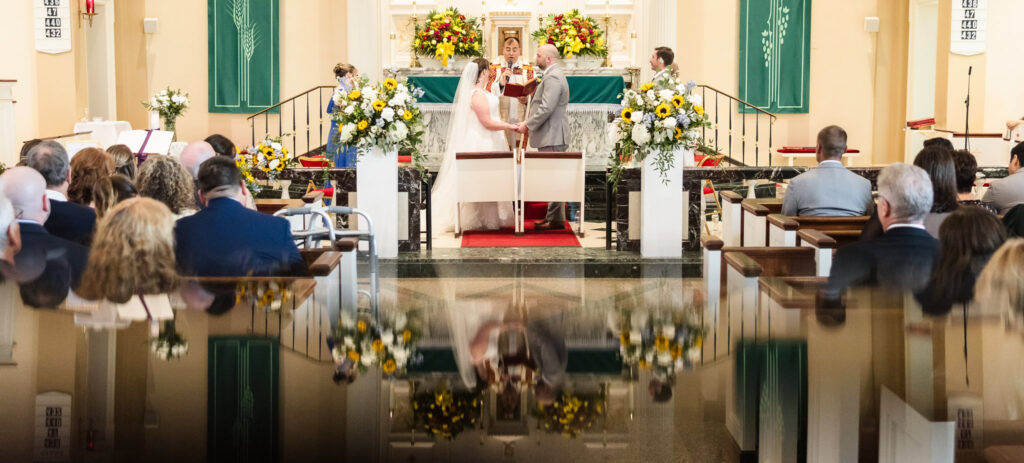 Bride and groom holding hands on the altar during the wedding ceremony.