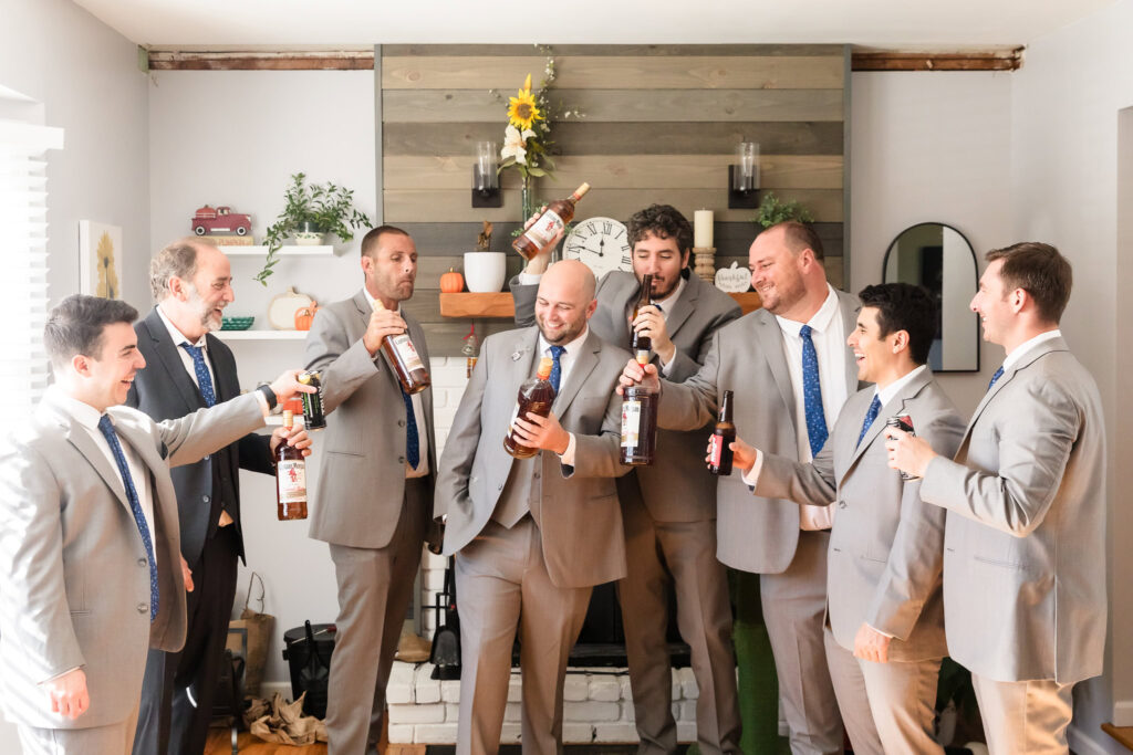 Groom and groomsmen toasting with bottles before the weddding.