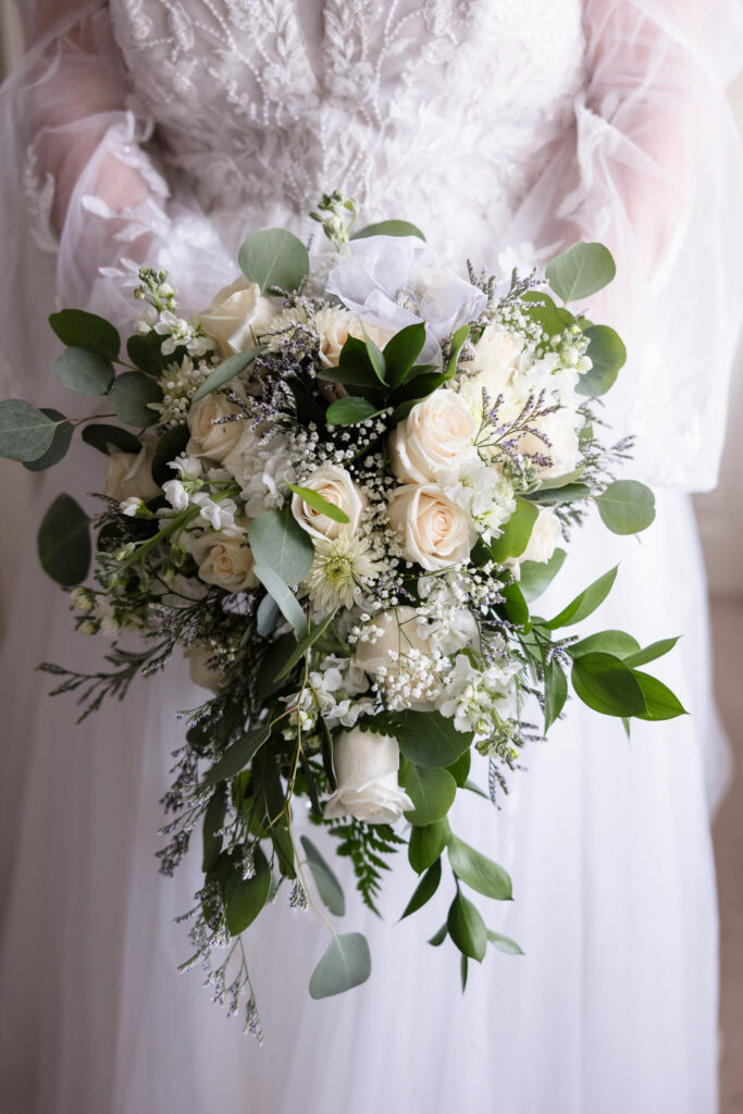 Bride holding her flowers. The images is only of her flowers and arms.