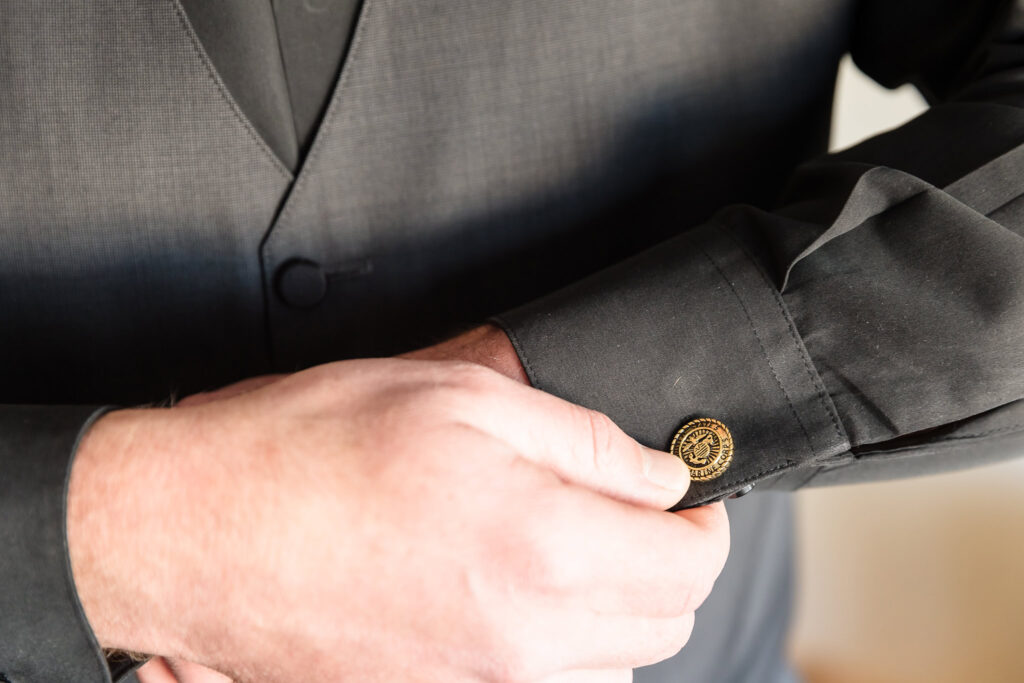 Groom putting on his cufflinks.