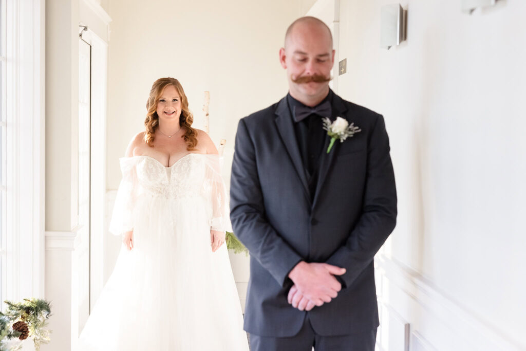 Bride approaching groom during first look at Stewart Manor Country Club.