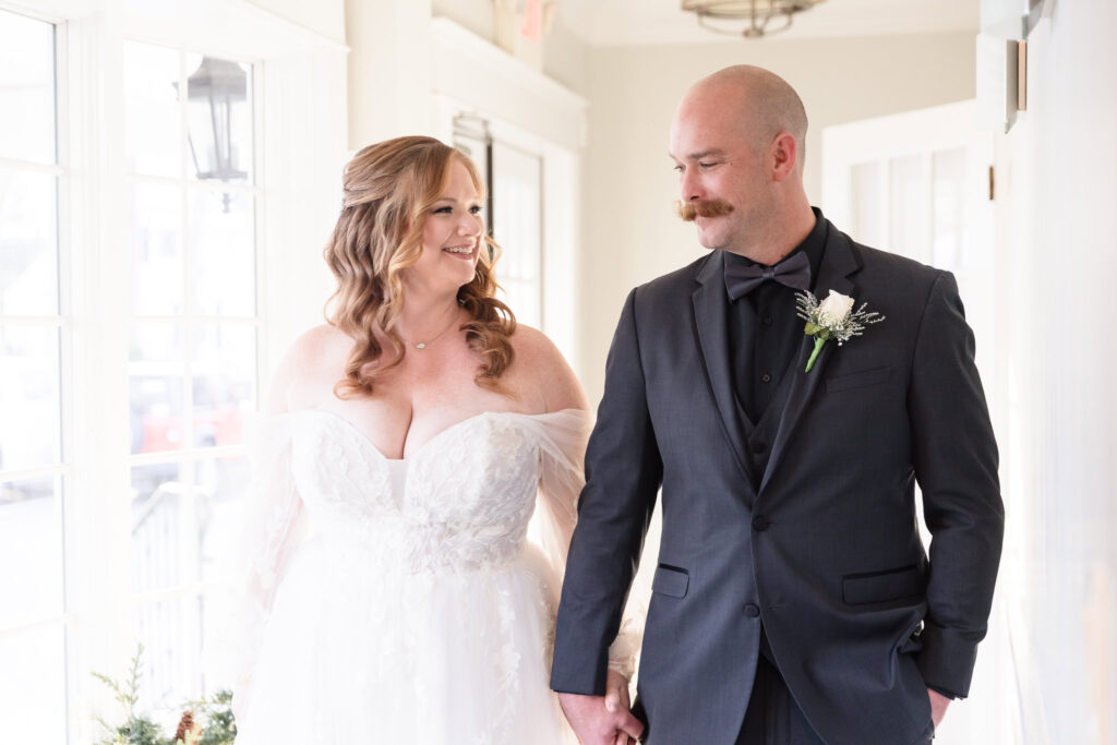 Bride and groom looking at each other during the first look and their Stewart Manor Country Club wedding. Both are smiling.