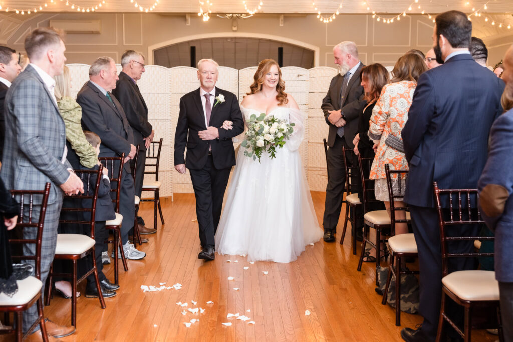 Bride and her father walking down the aisle for her wedding at Stewart Manor Country Club.