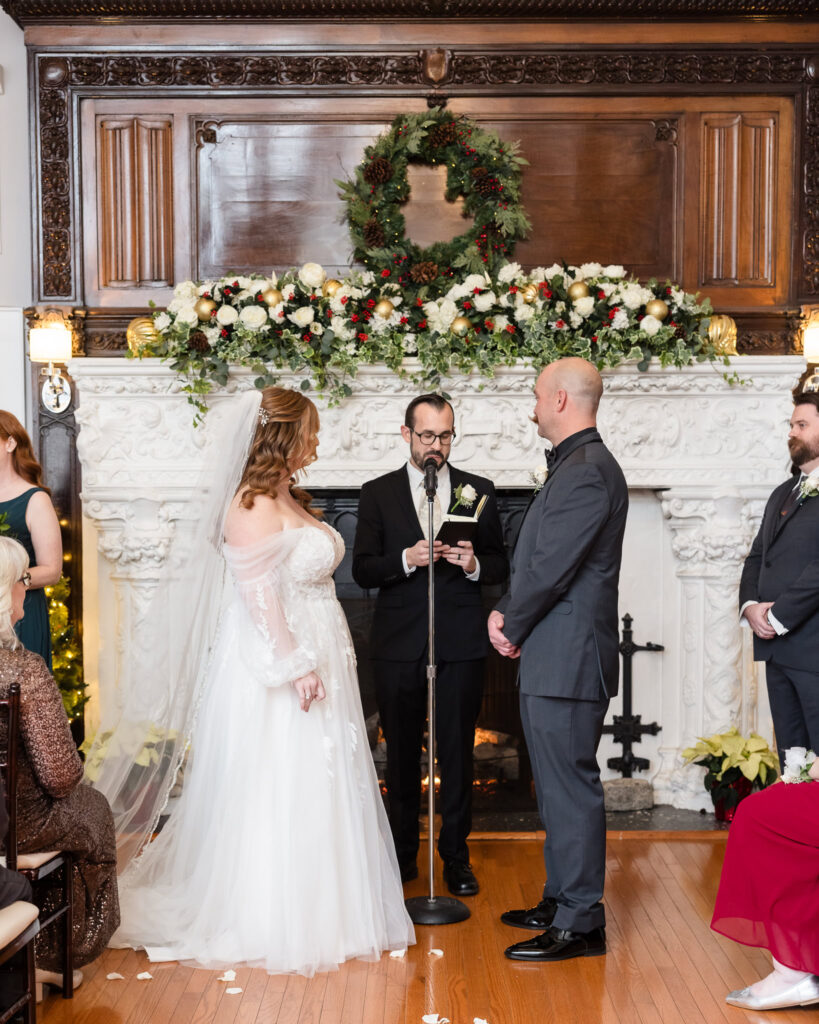 Bride and groom looking at officiant during ceremony at Stewart Manor Country Club.