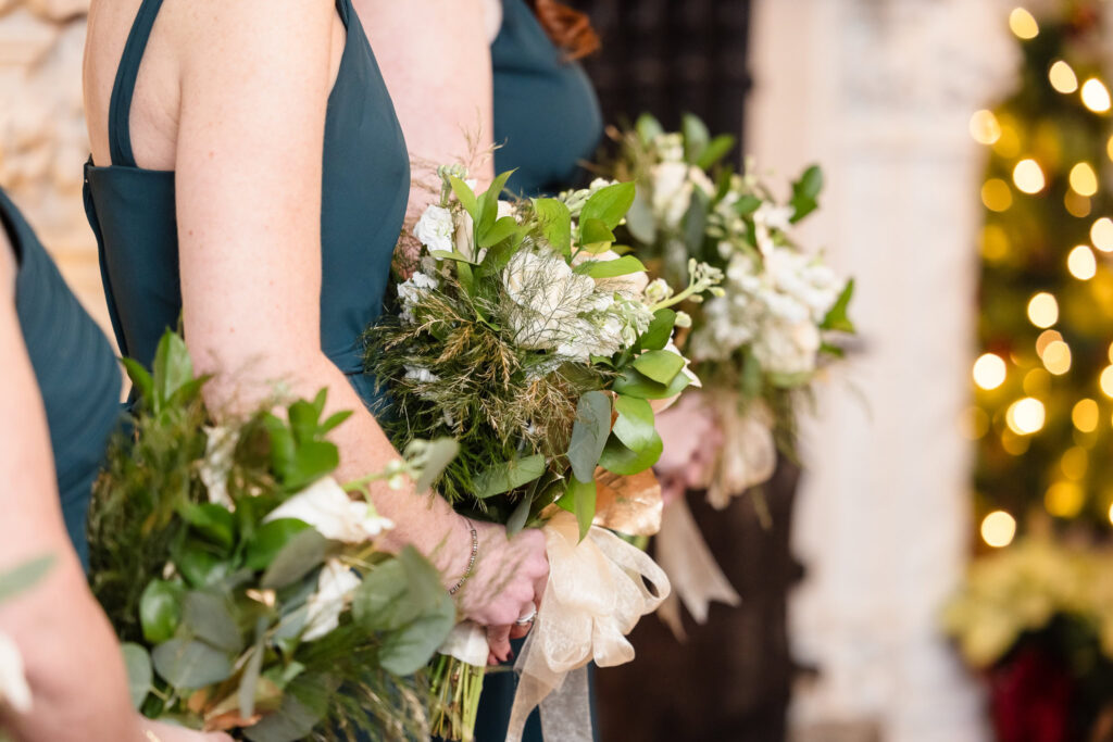 Bouquets of flowers held by  bridesmaids during wedding ceremony at Stewart Manor Country Club. 