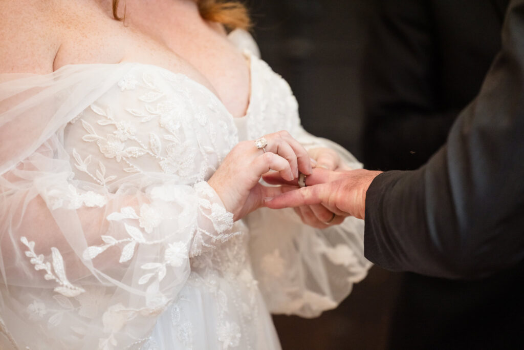 Bride giving groom a ring. 