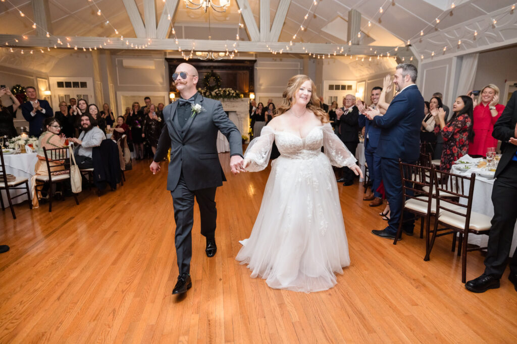 Bride and groom celebrating while entering wedding reception at Stewart Manor Country Club.