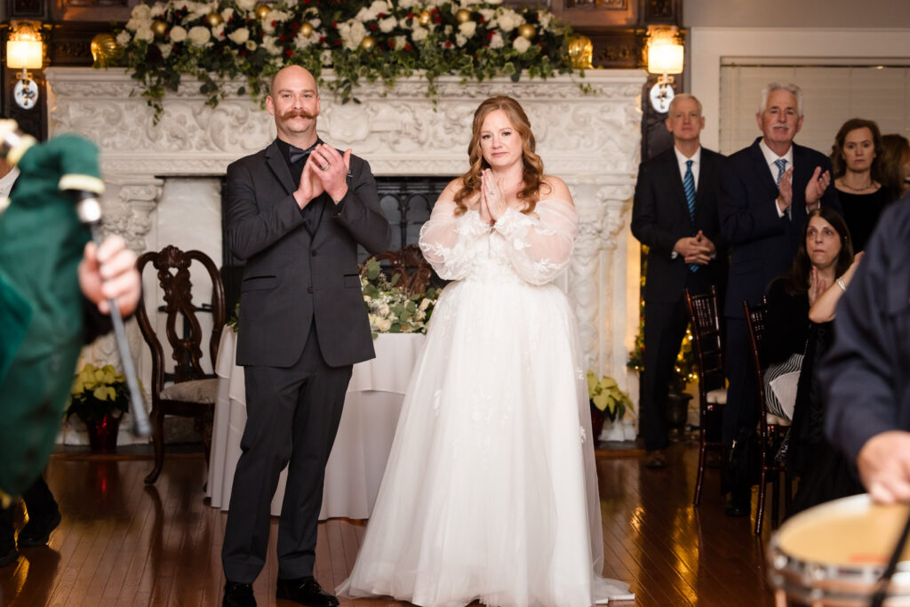 Bride and groom clapping for bagpipers.