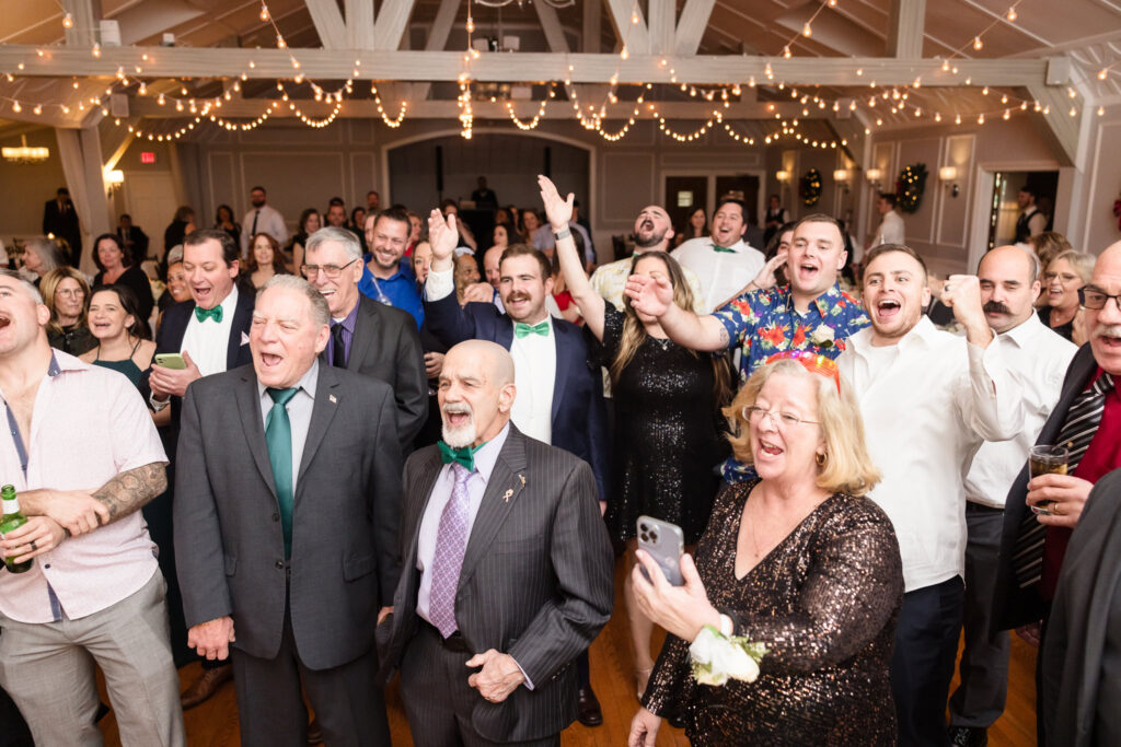 Guests in wedding reception cheering. 