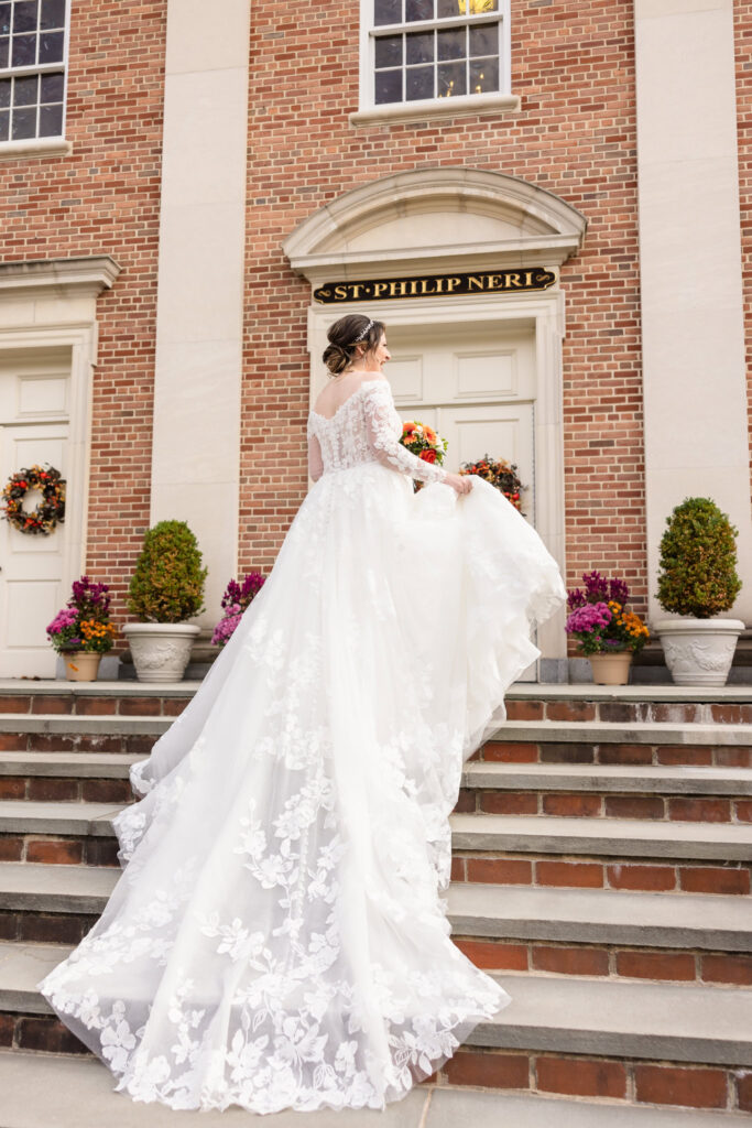 Bride holding her dress while she walks into chruch.