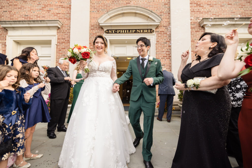 Bride and groom smiling as they exit the church.